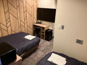 Postel nebo postele na pokoji v ubytování HOTEL LiVEMAX Mihara Ekimae
