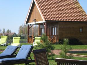 a house with two lounge chairs and a building at Les Augustines in Quend