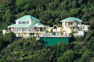 a large house on top of a hill at Villa Luminara Caribbean Retreat and Beaching in Oyster Pond
