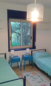 a room with two beds and two tables and a window at Villa Amenta in Fontane Bianche