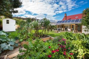 a garden in front of a house with solar panels at Brampton Cottage in Hobart