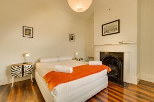 1 dormitorio con 1 cama y chimenea en Brampton Cottage en Hobart
