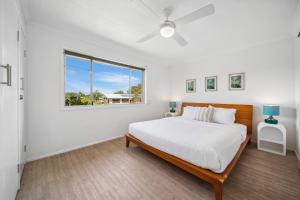 a white bedroom with a large bed and a window at Tides & Tails Abode - Coolum Beach Pet Friendly Home in Coolum Beach +21 photos