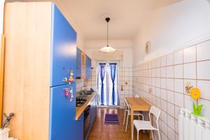 ローマにあるRomantic Ciclamini Houseのキッチン(青い冷蔵庫、テーブル付)