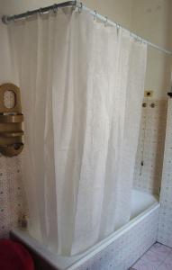 a white shower curtain on a tub in a bathroom at B&B Early Leaving Bergamo Airport in Bergamo