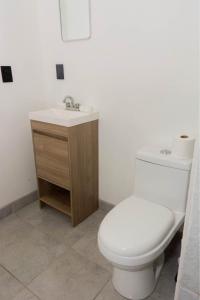 a bathroom with a white toilet and a sink at Cabaña frente al mar in Coronel Esteban Cantú