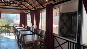 a row of tables in a room with windows at Villa Bella in Ooty