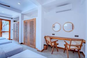 The Green Rooms Surf & Yoga Camp - ON THE BEACH - Prime location Renovated 2024 في يليغاما: غرفة نوم مع مكتب وسرير ومرآة