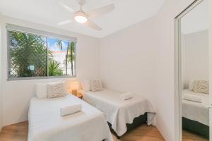 Cette chambre blanche dispose de deux lits et d'une fenêtre. dans l'établissement Oceanside Resort - Absolute Beachfront Apartments, à Gold Coast 23 autres photos