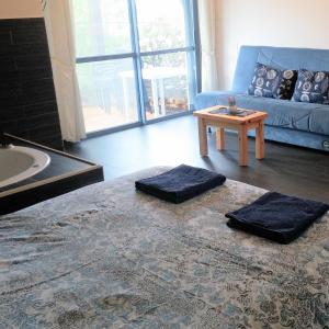 ein Wohnzimmer mit einem blauen Sofa und einem Tisch in der Unterkunft Greek Relaxation in Ma‘yan Barukh