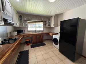 a kitchen with a black refrigerator and a dishwasher at Fare Matahani in HUH
