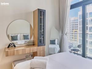 a bedroom with a mirror and a bed and a window at bnbmehomes - Azizi Riviera 45 in Dubai +41 photos
