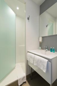 a white bathroom with a sink and a shower at ibis budget Cannes Centre Ville in Cannes