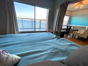 een slaapkamer met een bed met uitzicht op de oceaan bij villa chillon in Shodoshima +60 foto's