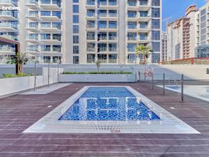 an empty swimming pool in a city with tall buildings at bnbmehomes - Azizi Riviera 45 in Dubai