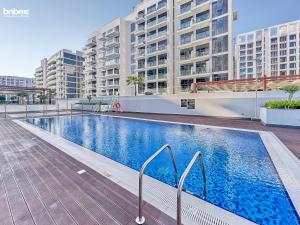 a swimming pool in a building with tall buildings at bnbmehomes - Azizi Riviera 45 in Dubai