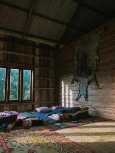 a room with three beds in a log cabin at De Lueb Domitory in Ban Houayman