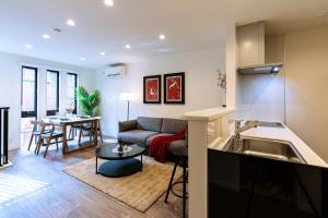 a kitchen and living room with a couch and a table at J S暁宅-睦月 mutsuki in Osaka