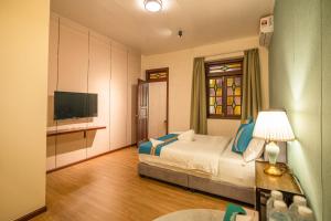 a hotel room with a bed and a television at Penang Story LINN House in George Town