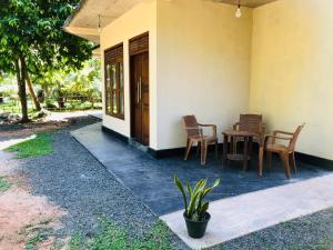 a porch of a house with a table and chairs at Wakishta Villa - Weligama in Weligama