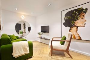 a living room with a green couch and a chair at Elysia by Joja in Lagos