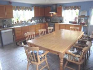 a kitchen with a wooden table and chairs at Hethersett Lodge in Norwich