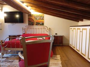 a room with a bed and a tv on the wall at Monte Etna Confòrt Maison in Linguaglossa