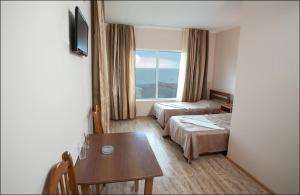 ウレキにあるHotel Premiumのベッド2台、テーブル、窓が備わるホテルルームです。