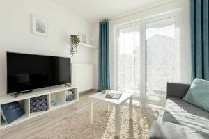 a living room with a large flat screen tv at Spacious Apartment with Balcony in Gdańsk by Rent like home in Gdańsk