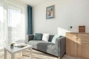 a living room with a couch and a table at Spacious Apartment with Balcony in Gdańsk by Rent like home in Gdańsk +12 photos