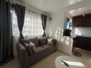 a living room with a couch in front of a window at Royal apartments Eldoret in Eldoret
