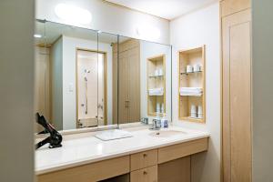 a bathroom with a sink and a large mirror at Seagaia Forest Condominiums in Miyazaki