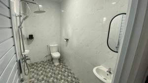 a white bathroom with a toilet and a sink at Asaan homestay in Ciburial