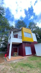 a red and white house with a yellow roof at Asaan homestay in Ciburial +6 photos