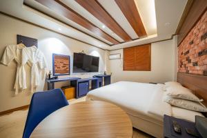 a bedroom with a bed and a table and a tv at Lounge Seoul in Icheon