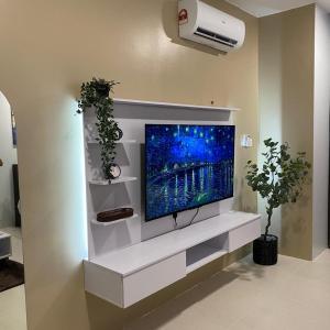 a flat screen tv on a wall in a living room at LeStarry Homestay in Kuching