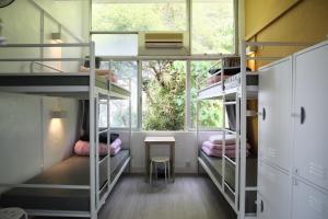 a room with bunk beds with a table and a window at YHA Jockey Club Mt. Davis Youth Hostel in Hong Kong