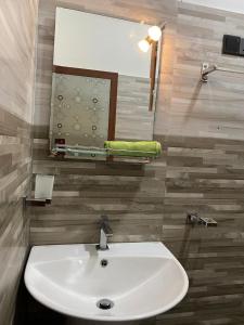 a bathroom with a white sink and a mirror at Labuduwa Rest in Galle
