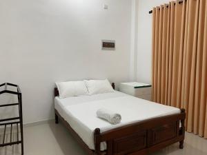a small bedroom with a bed and a heater at Labuduwa Rest in Galle