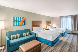 スポケーンにあるMainStay Suites Spokane Airportのベッド2台とソファがあるホテルの部屋