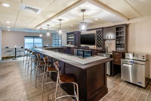 スポケーンにあるMainStay Suites Spokane Airportの大きなキッチン(長いバー、スツール付)