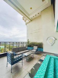 a balcony with a pool and two benches next to a building at Vincondotel Malate Manila 2BR Admiral 2823 in Manila