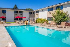 a pool with chairs and tables in front of a hotel at Econo Lodge in Idaho Falls