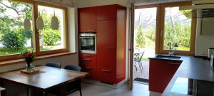 a kitchen with red cabinets and a wooden table at Appartment Gut Wendlandt in Bolzano