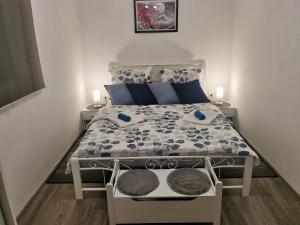a small bedroom with a bed with blue and white sheets at Apartman M&L in Žgaljić