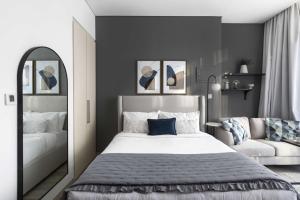 a bedroom with a large white bed and a chair at Silkhaus Dubai Financial Center studio in Burj Daman in Dubai