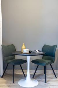 a table with two green chairs and a table with a lamp at Silkhaus Dubai Financial Center studio in Burj Daman in Dubai