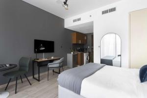 a bedroom with a bed and a desk and a kitchen at Silkhaus Dubai Financial Center studio in Burj Daman in Dubai