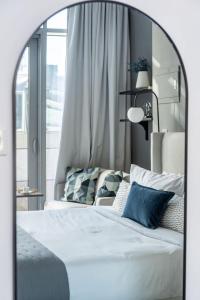 a bedroom with a bed with blue and white pillows at Silkhaus Dubai Financial Center studio in Burj Daman in Dubai