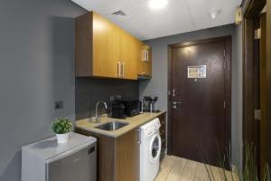 a kitchen with a sink and a washing machine at Silkhaus Dubai Financial Center studio in Burj Daman in Dubai